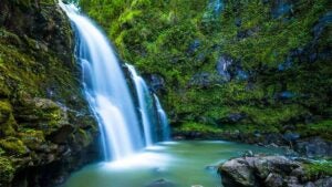 close up of Secret Falls with rocks covered in green moss at Wailua River in Kauai, Hawaii, USA